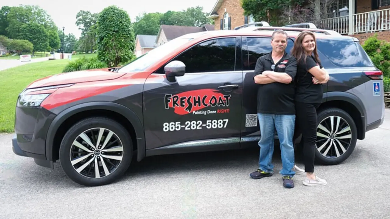 Photo of Jeff and Jenn Berry standing in front of their Fresh Coat Painters vehicle