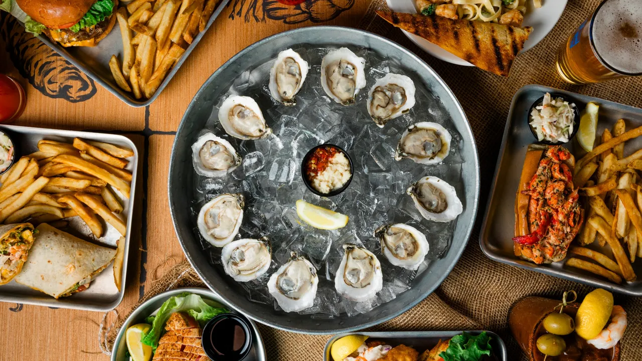 Photo of spread of Shuckin' Shack menu items on table featuring oysters in the middle