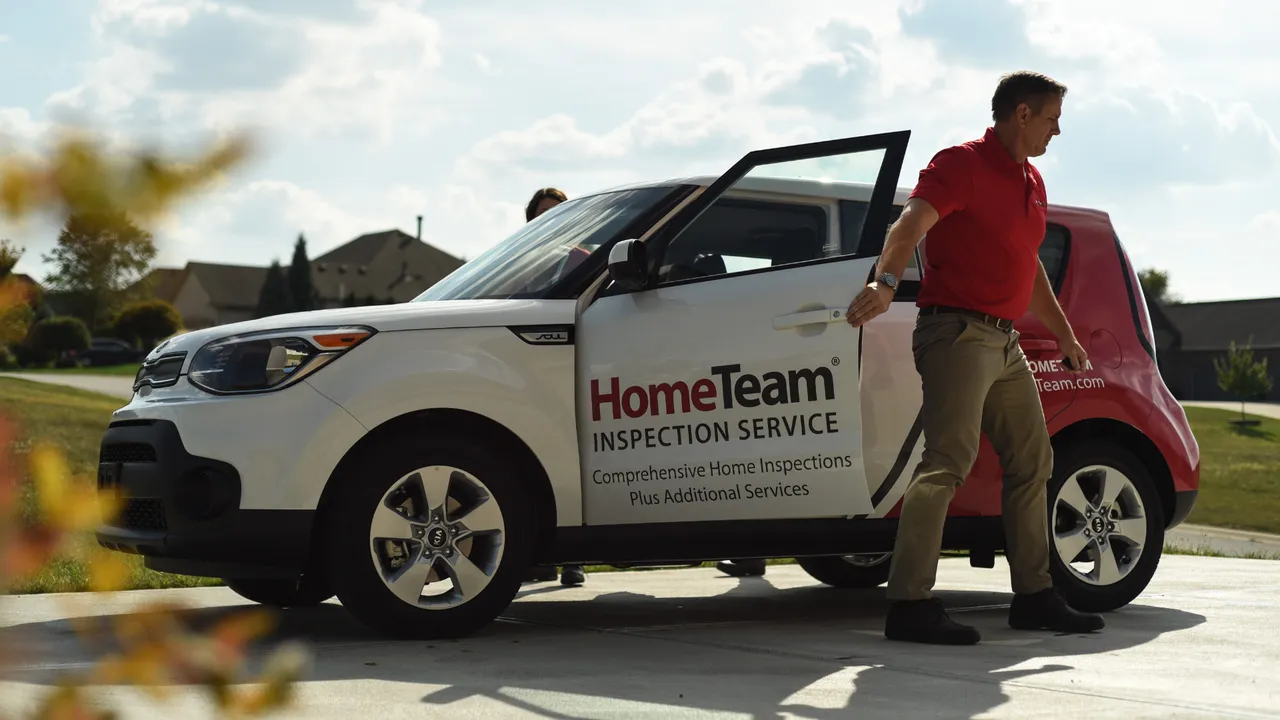 Photo of HomeTeam team member exiting branded vehicle in khakis and red polo