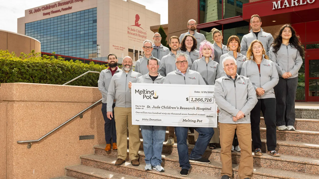 Melting Pot team holding $1.2 million check addressed to St. Jude Children's Research Hospital