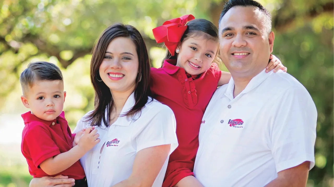 Photo of two Fresh Coat franchisees and their family
