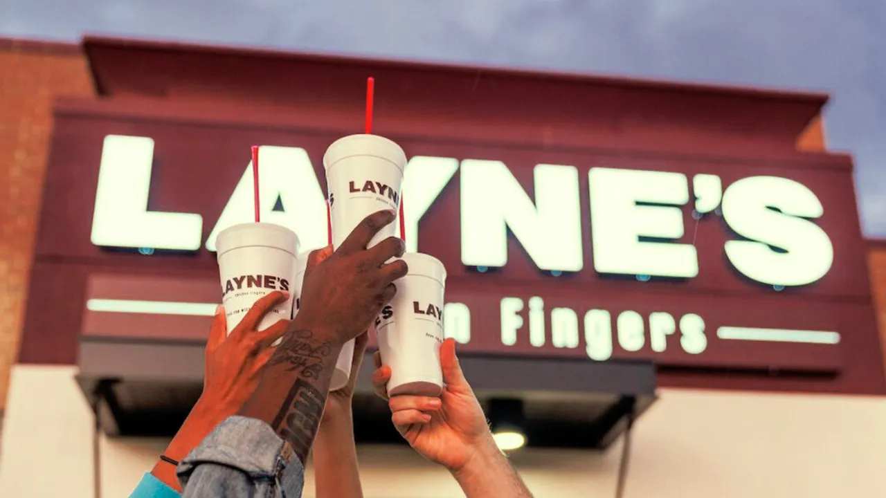 image of laynes chicken finger restaurant with 4 hands holding cups in the air to celebrate 
