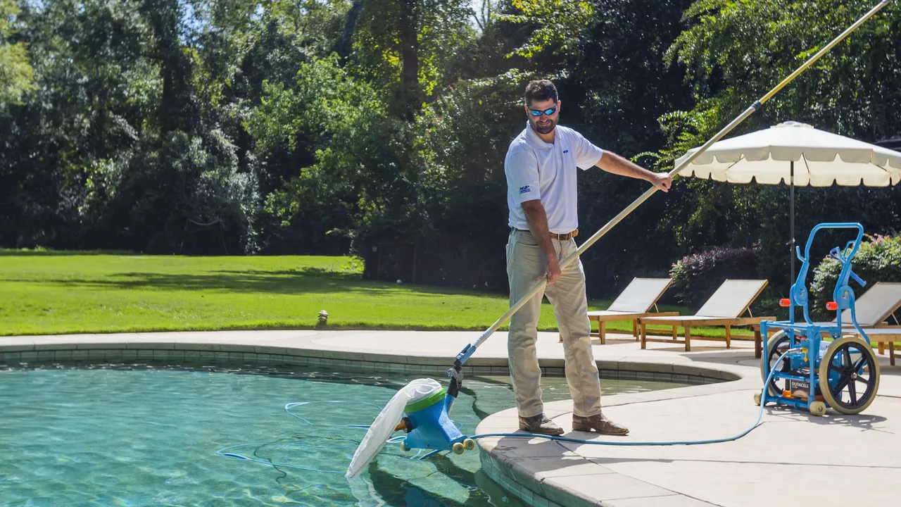image of a americas swimming pool employee cleaning a spotless pool franchise success