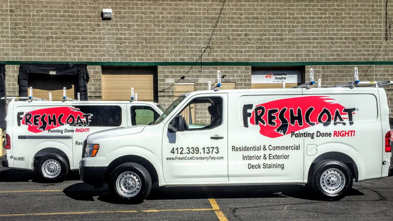 Photo of two Fresh Coat vans parked outside a building