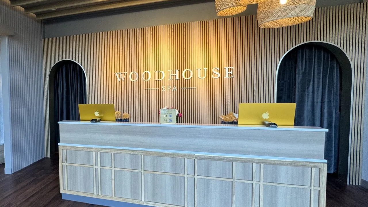 Photo of interior of Woodhouse Spa featuring front desk and wooden paneled wall
