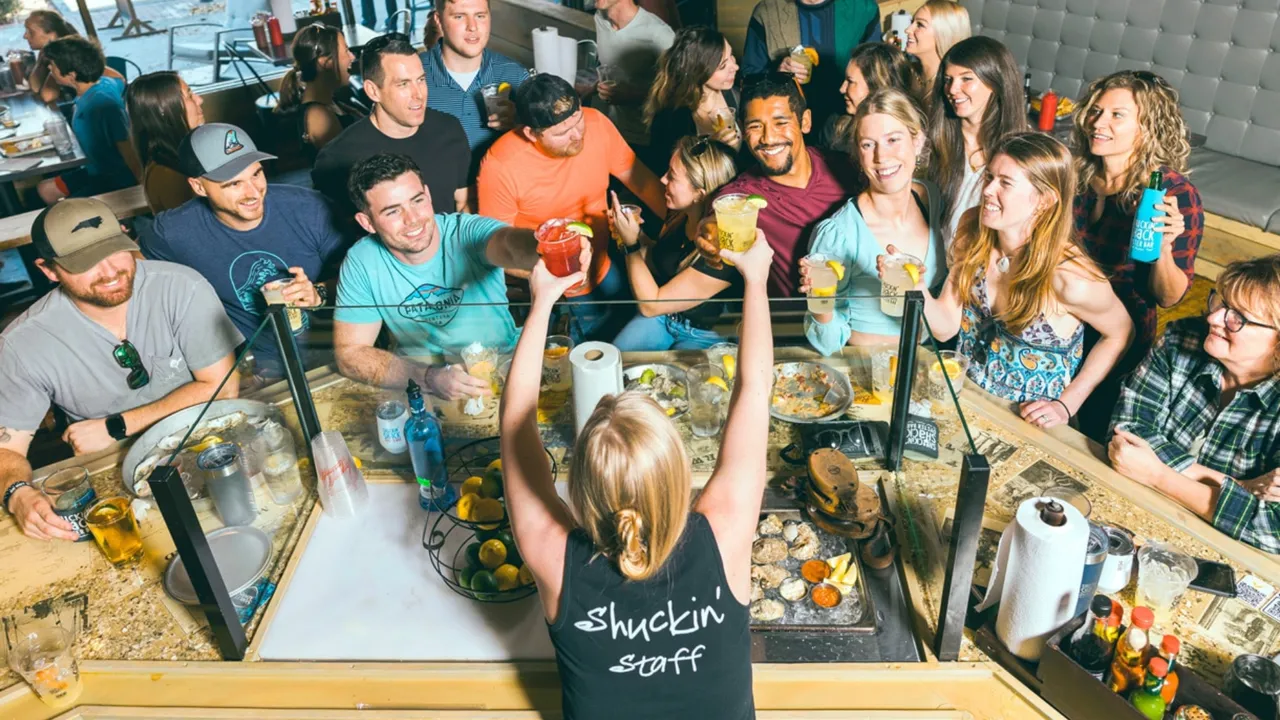 Photo of Shuckin' Shack team member handing drinks to guests