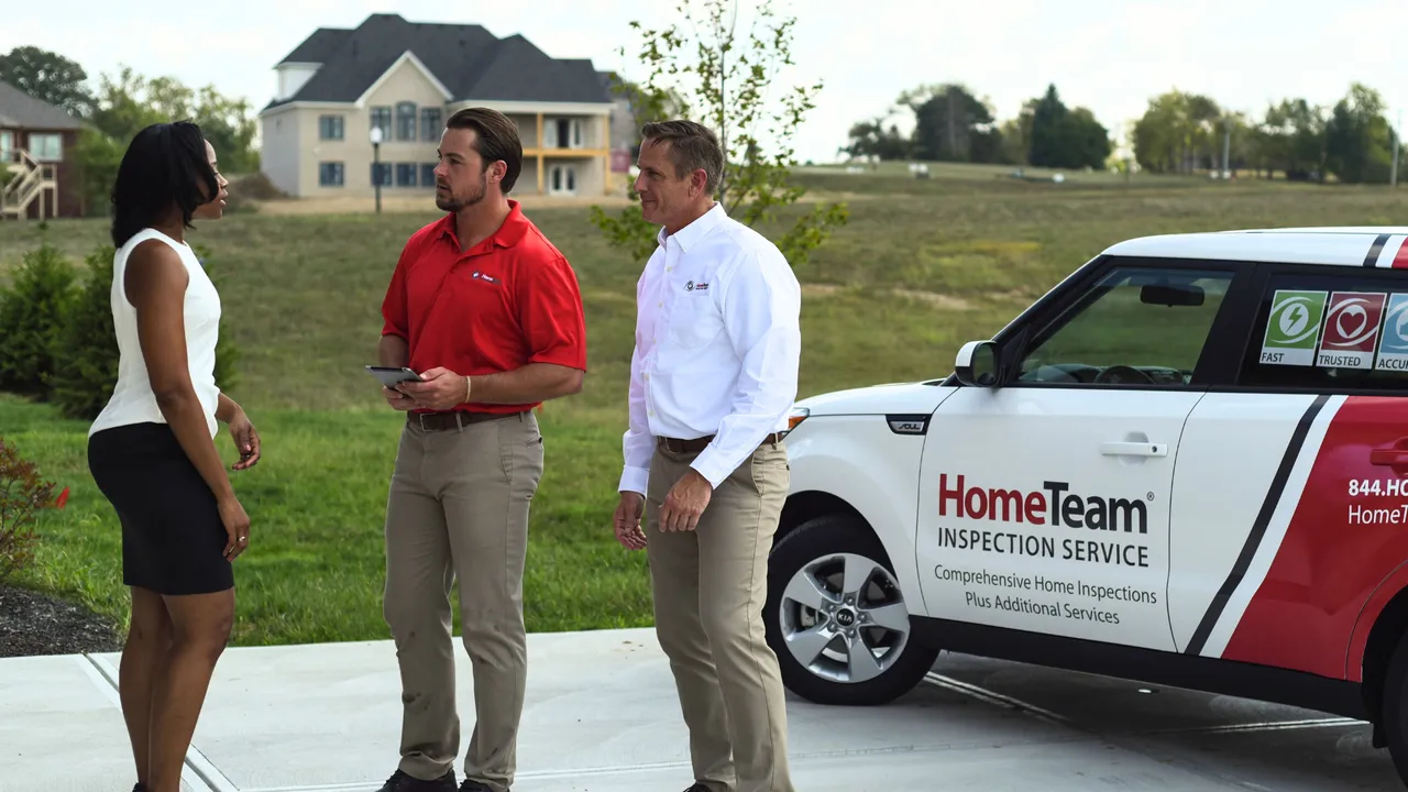 Photo of two HomeTeam team members speaking with person in white top and black skirt