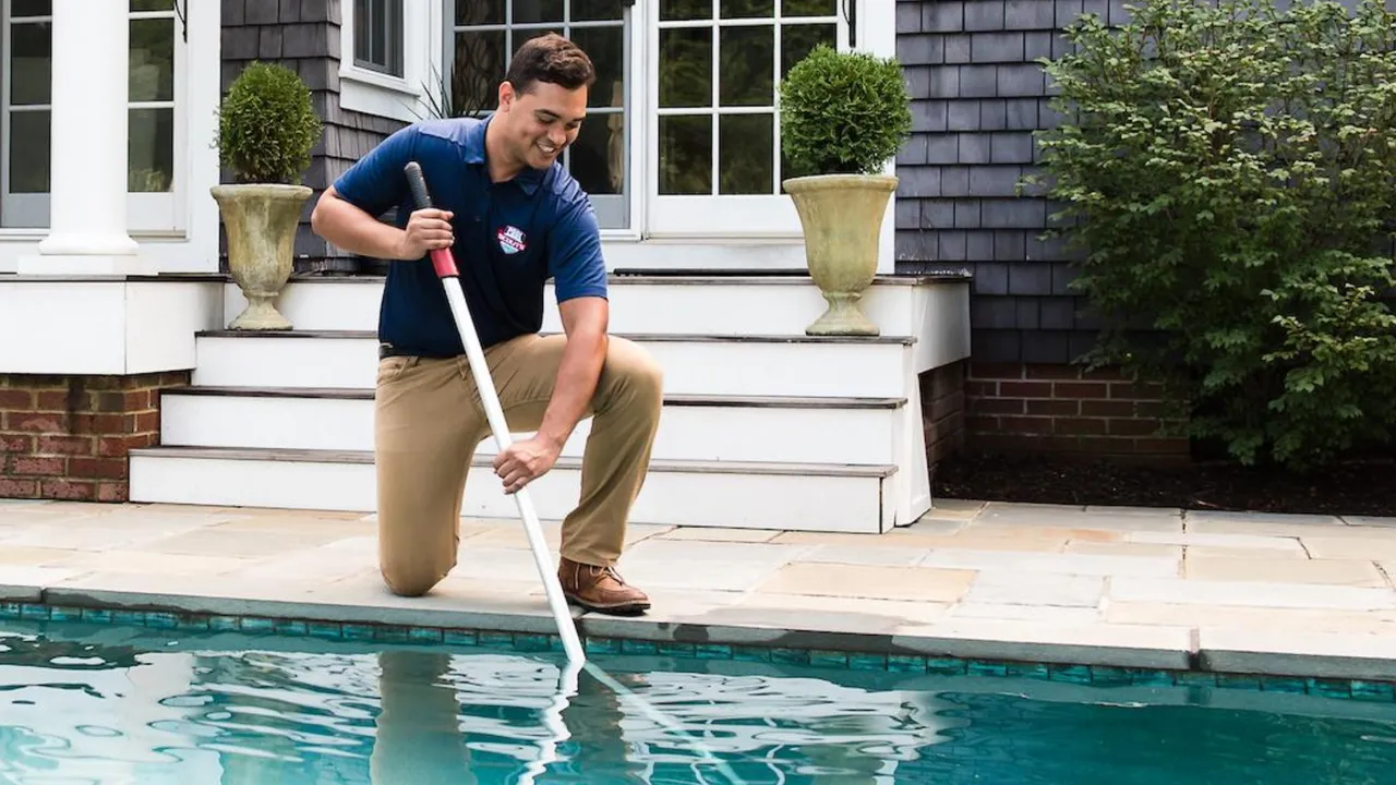 Photo of Pool Scouts team member kneeling by pool
