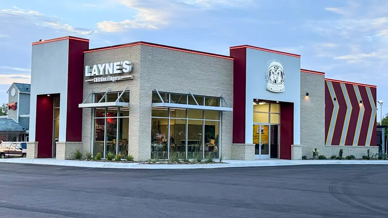 Photo of exterior of Layne's Chicken Fingers location with red lights around roof