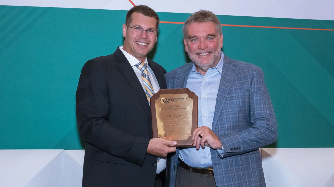 Minuteman Press Franchise Owner Tim Lorman (right) accepts Top Overall Performance Award.