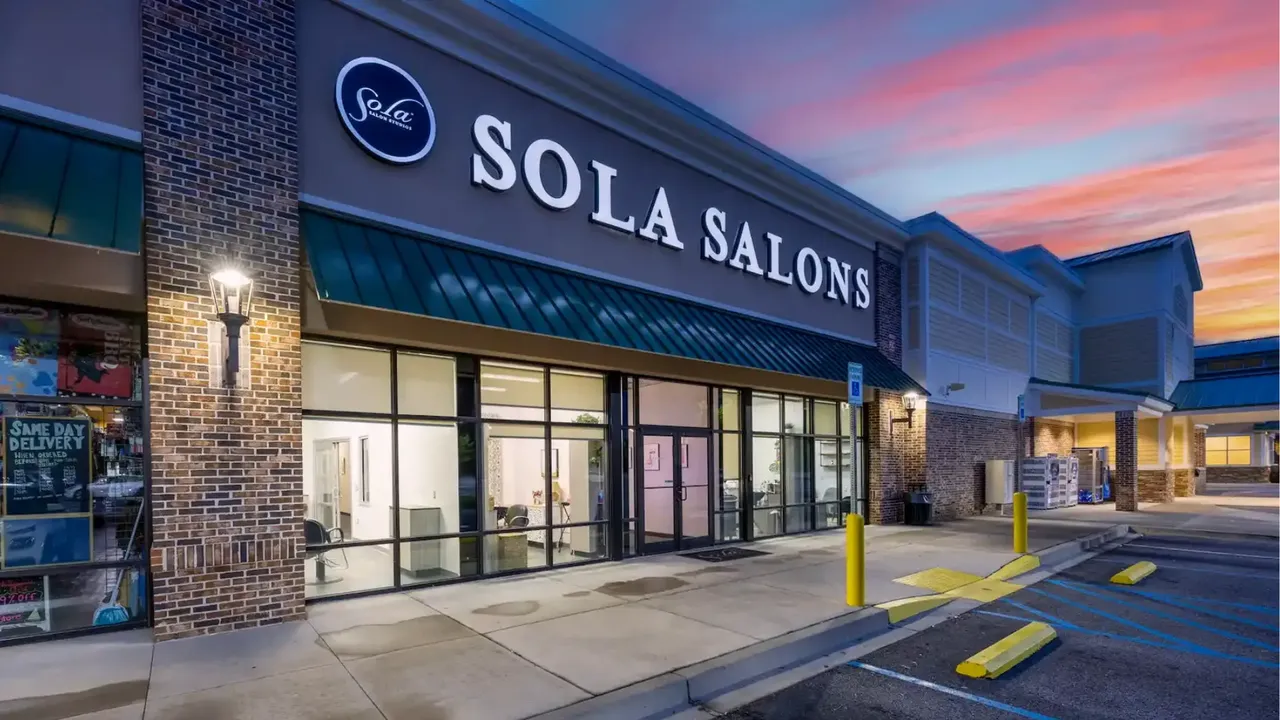 Photo of exterior of Sola Salons location with sunset in background