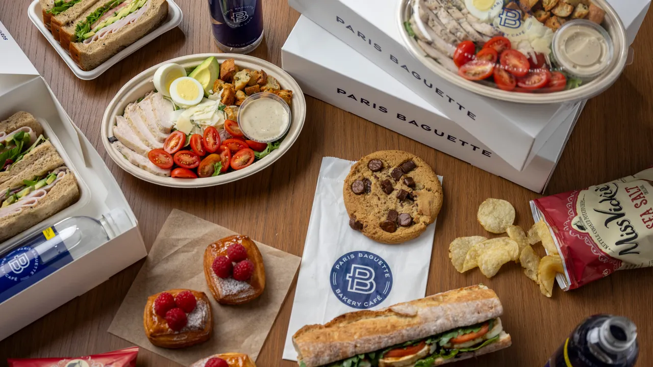 Photo of Paris Baguette catering spread with salad, sandwiches, pastries, cookies and chips