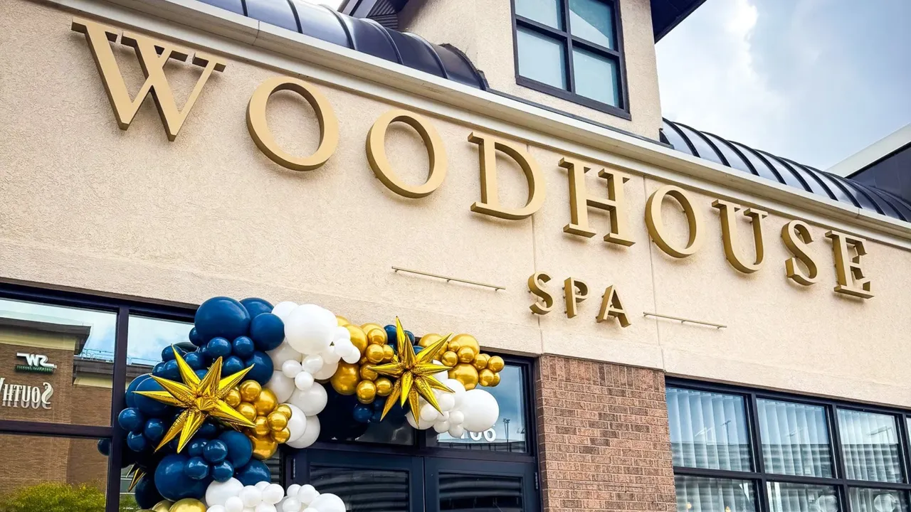Photo of exterior of Woodhouse Spa location with navy blue, white and gold balloons