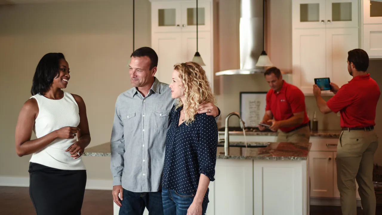 Photo of three people discussing, two HomeTeam inspectors reviewing kitchen