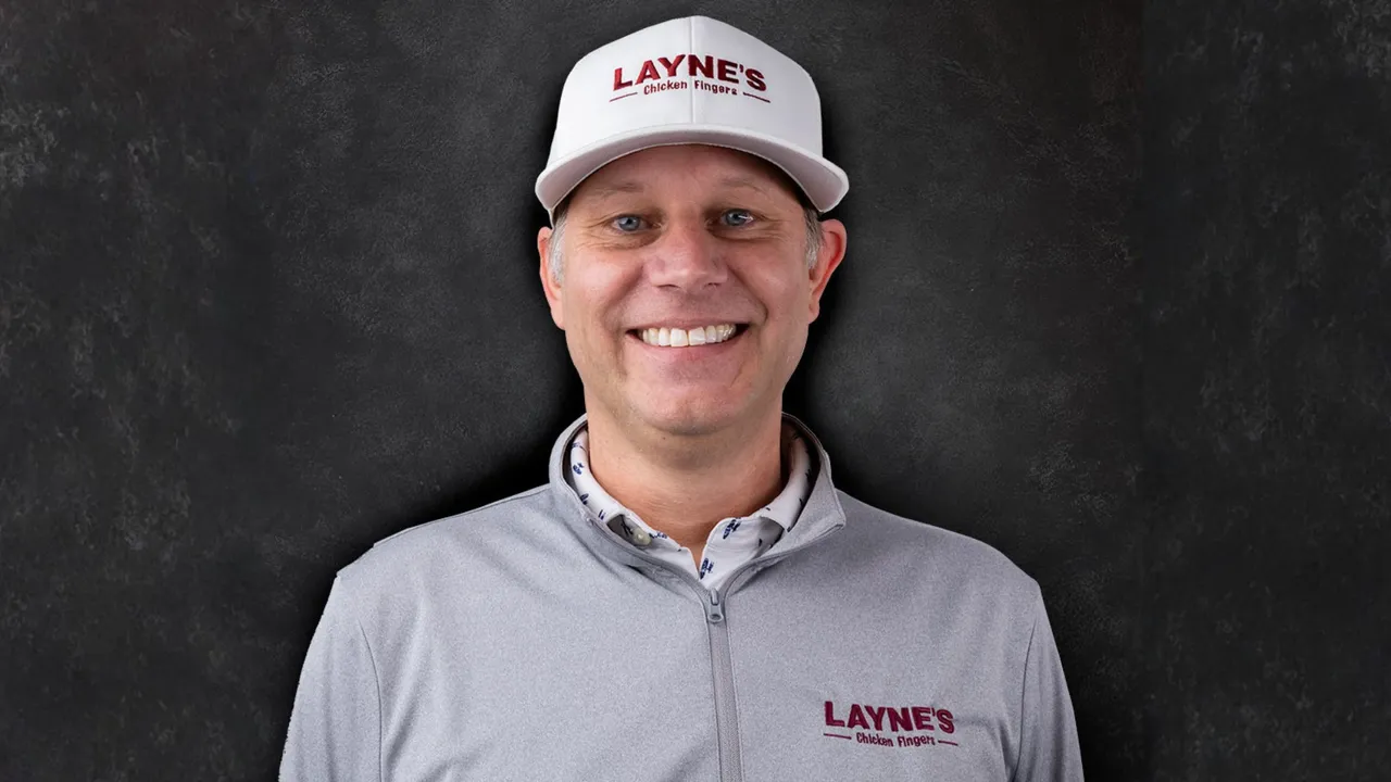 Photo of Layne's Chicken Fingers CEO Garrett Reed wearing Layne's hat and jacket