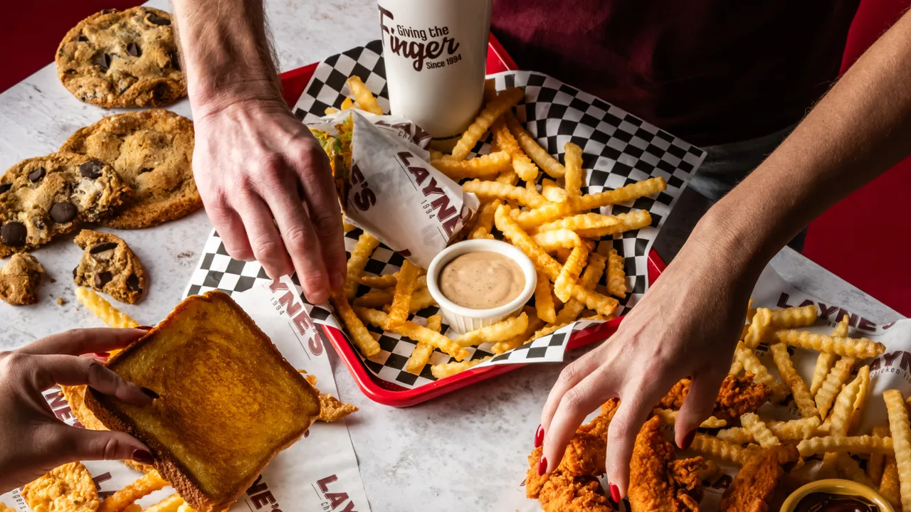 Photo of trays of Layne's fries, chicken fingers, wrap and toast on a table