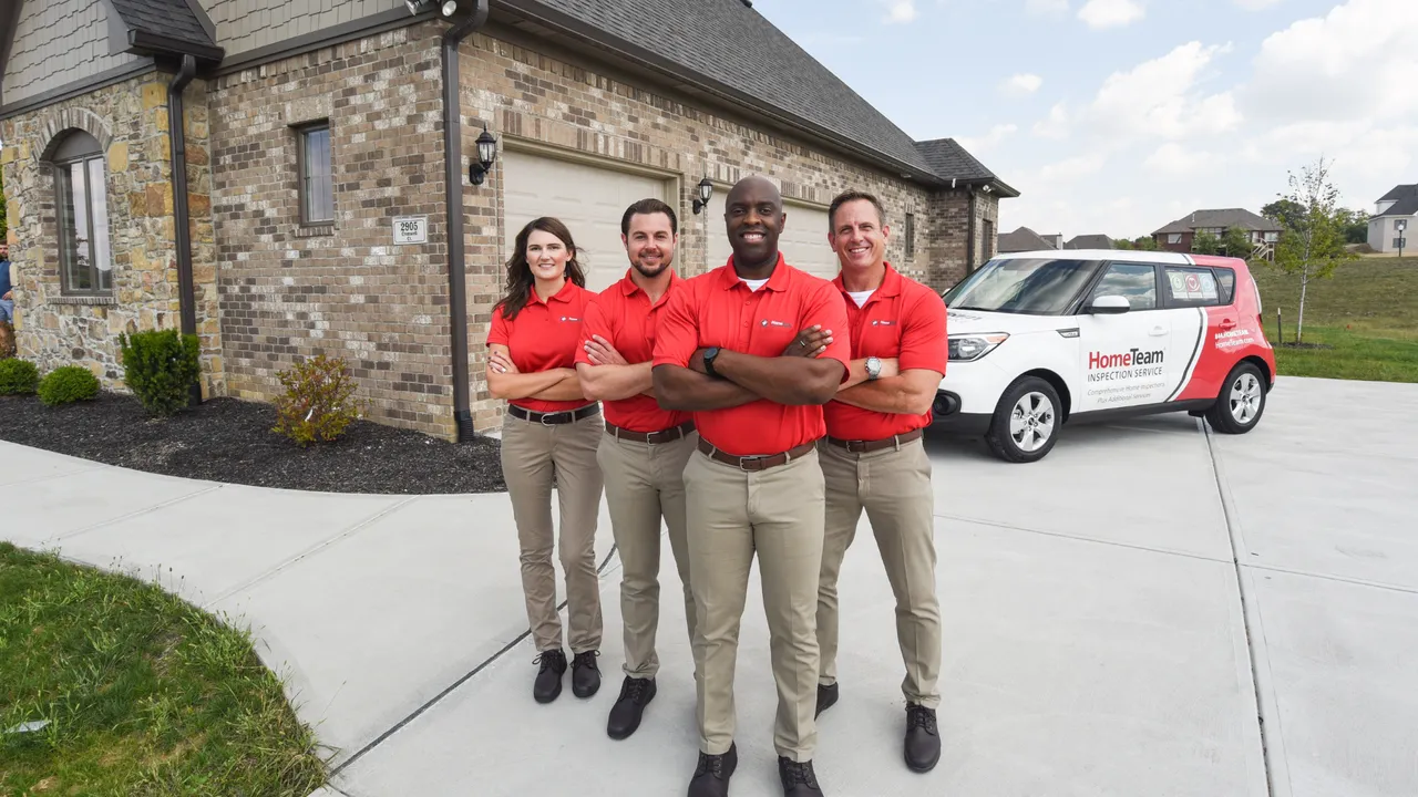 Photo of four HomeTeam inspectors standing together outside home