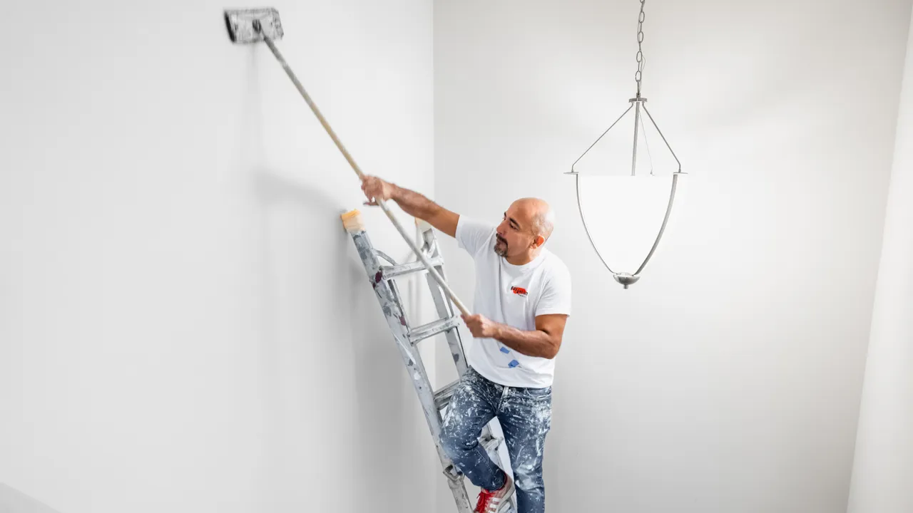 Photo of Fresh Coat Painters team member working on ladder