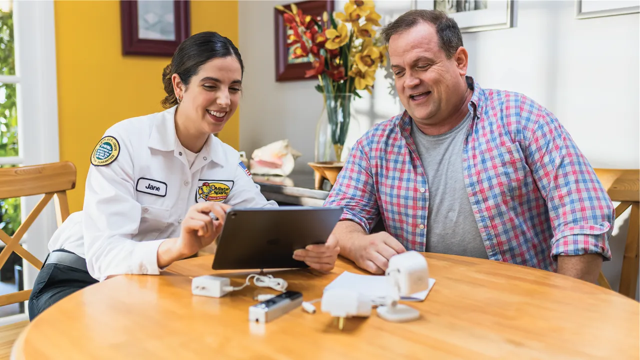 Photo of Mister Sparky team member and homeowner sitting at table