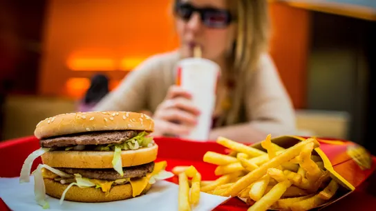 Woman eating a Big Mac and fries at McDonald's