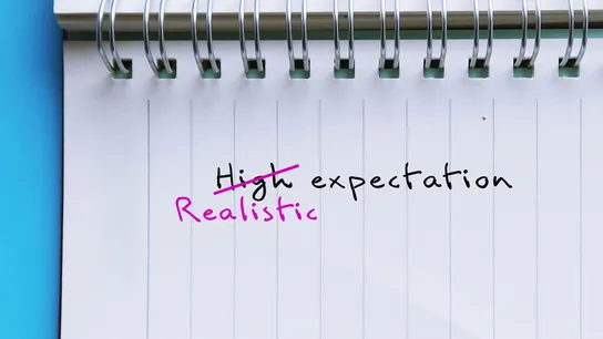 Notebook paper with "High expectation" written. "High" is crossed out and replaced with "Realistic"