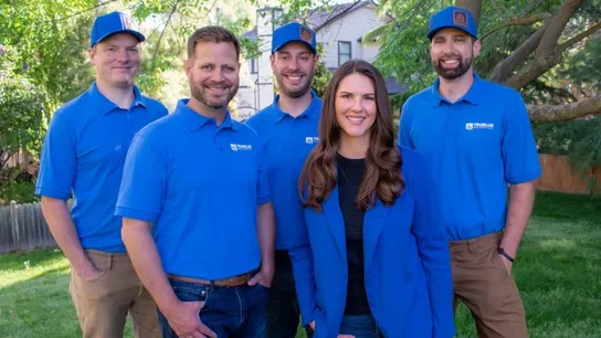a team of five TruBlue team members wearing branded polos and hats