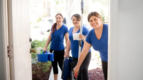 photo of three team members, all wearing blue short sleeve shirts, arriving to clean a home