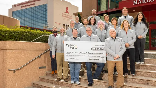 Melting Pot team holding $1.2 million check addressed to St. Jude Children's Research Hospital