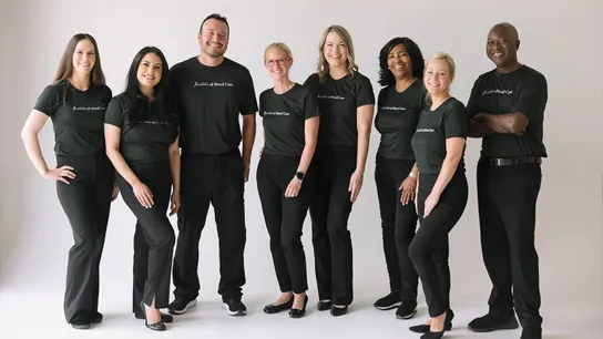 Photo of diverse team of Woodhouse Spa team members standing together, smiling