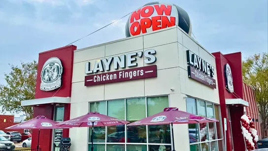 Photo of Layne's Chicken Fingers restaurant with "Now Open" inflatable on roof
