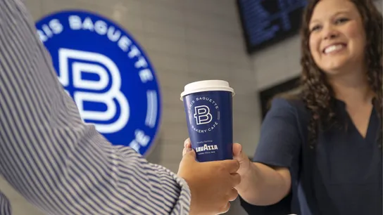Photo of person handing blue Paris Baguette coffee cup to guest