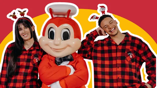 Photo of Jollibee mascot and two smiling people in Jollibee pajamas