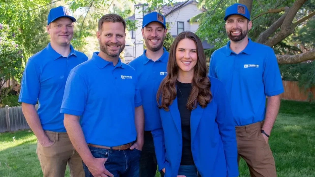 a team of five TruBlue team members wearing branded polos and hats