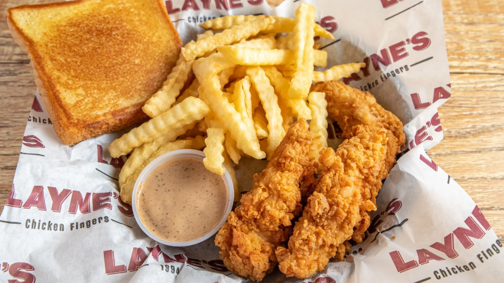 photo of Layne's chicken fingers, fries, toast and sauce in a basket