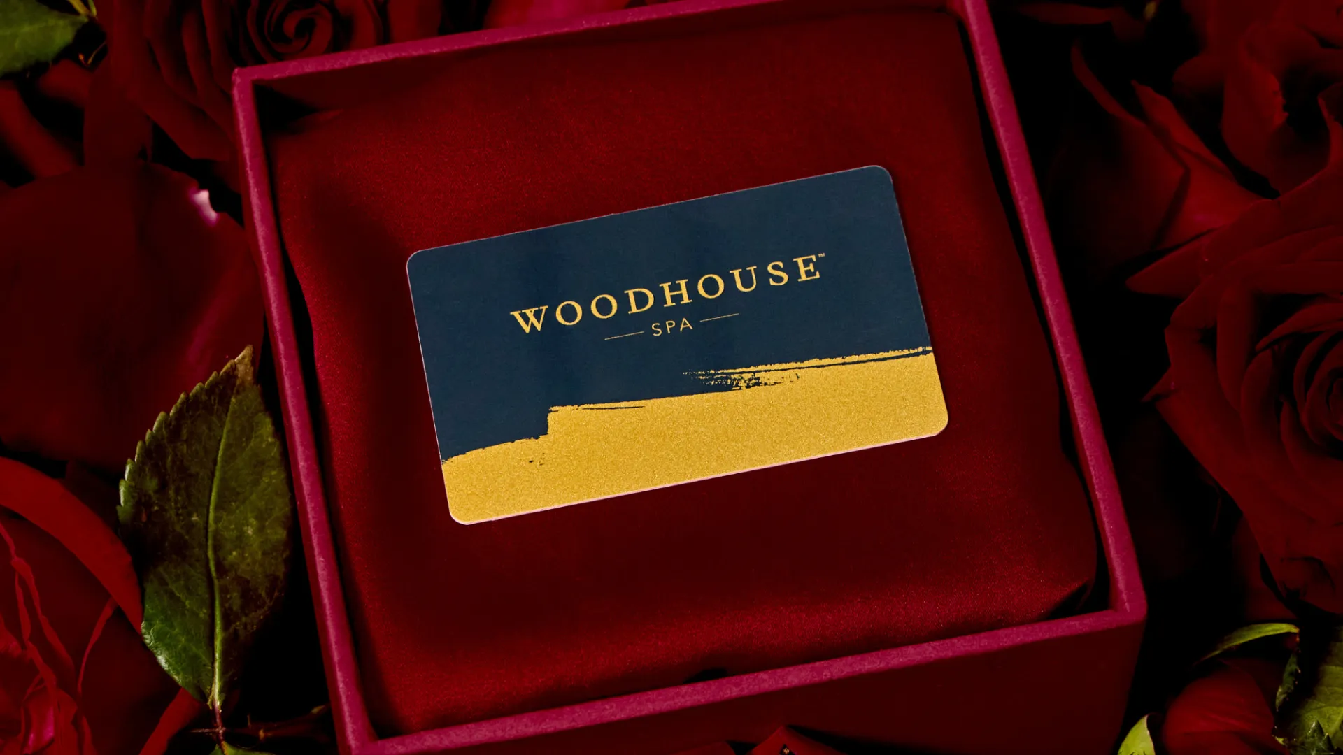 photo of a Woodhouse Spa gift card in red velvet gift box surrounded by roses