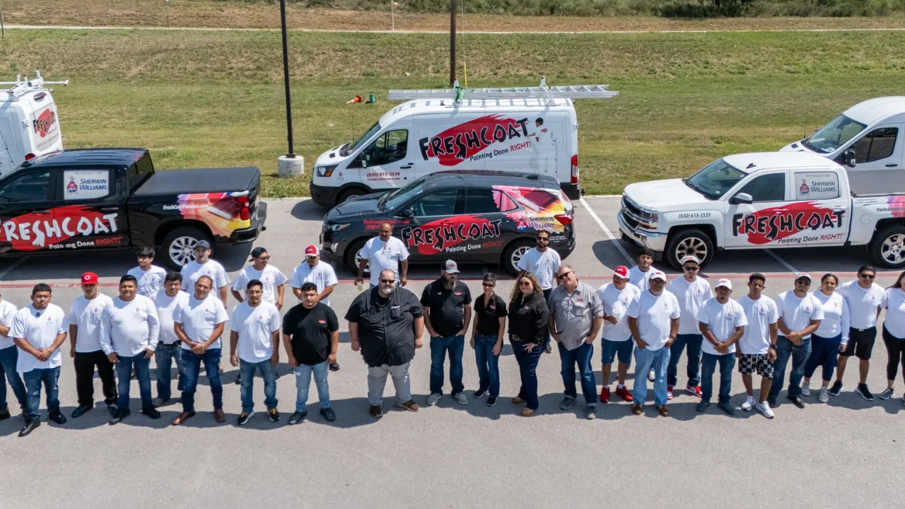 photo of a large Fresh Coat Painters team, including multiple Fresh Coat branded vehicles