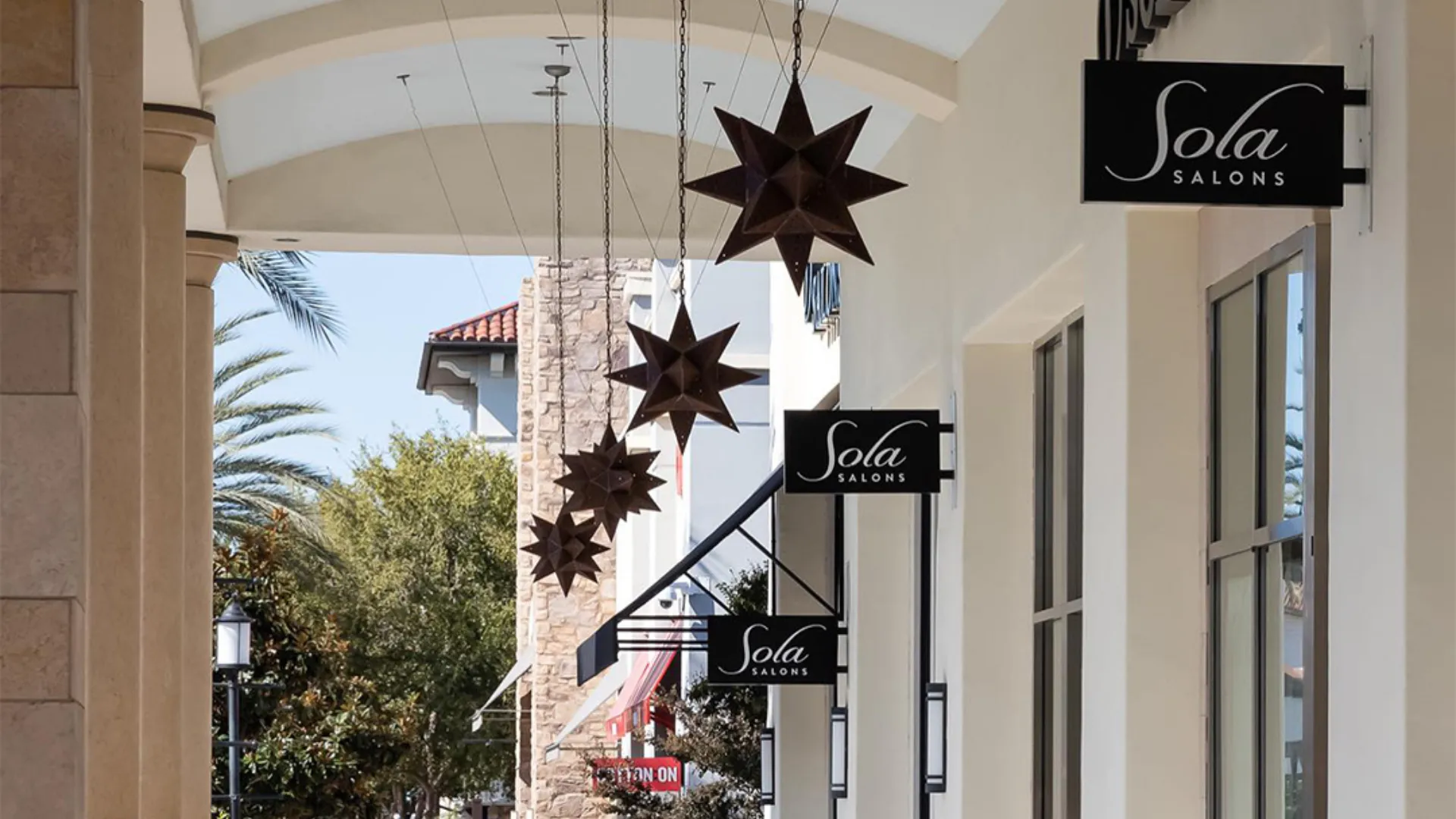 photo of the exterior of a Sola Salons unit with branded signs and geometric lighting fixtures