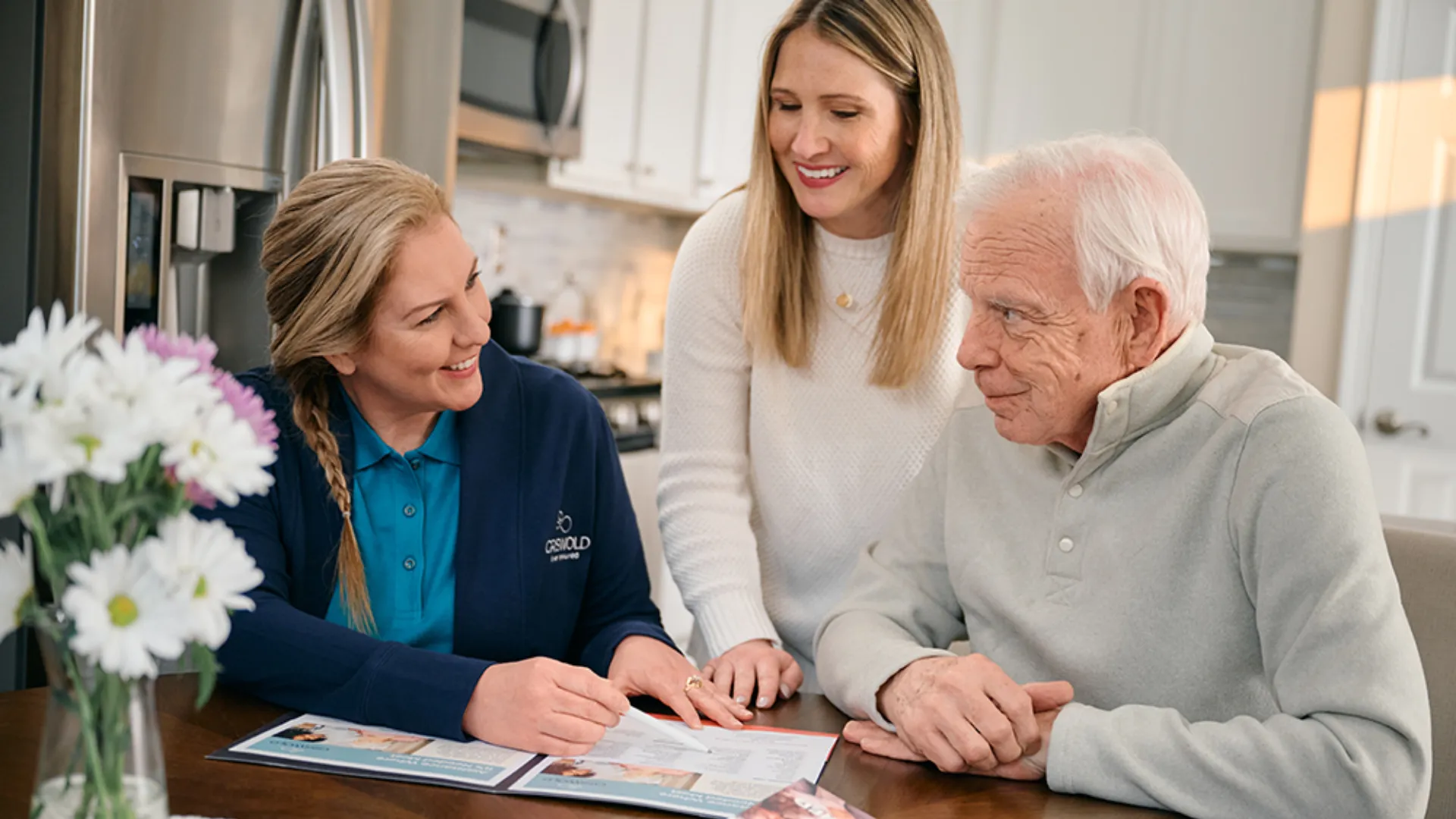 photo of a Griswold employee and two clients sitting at a kitchen table