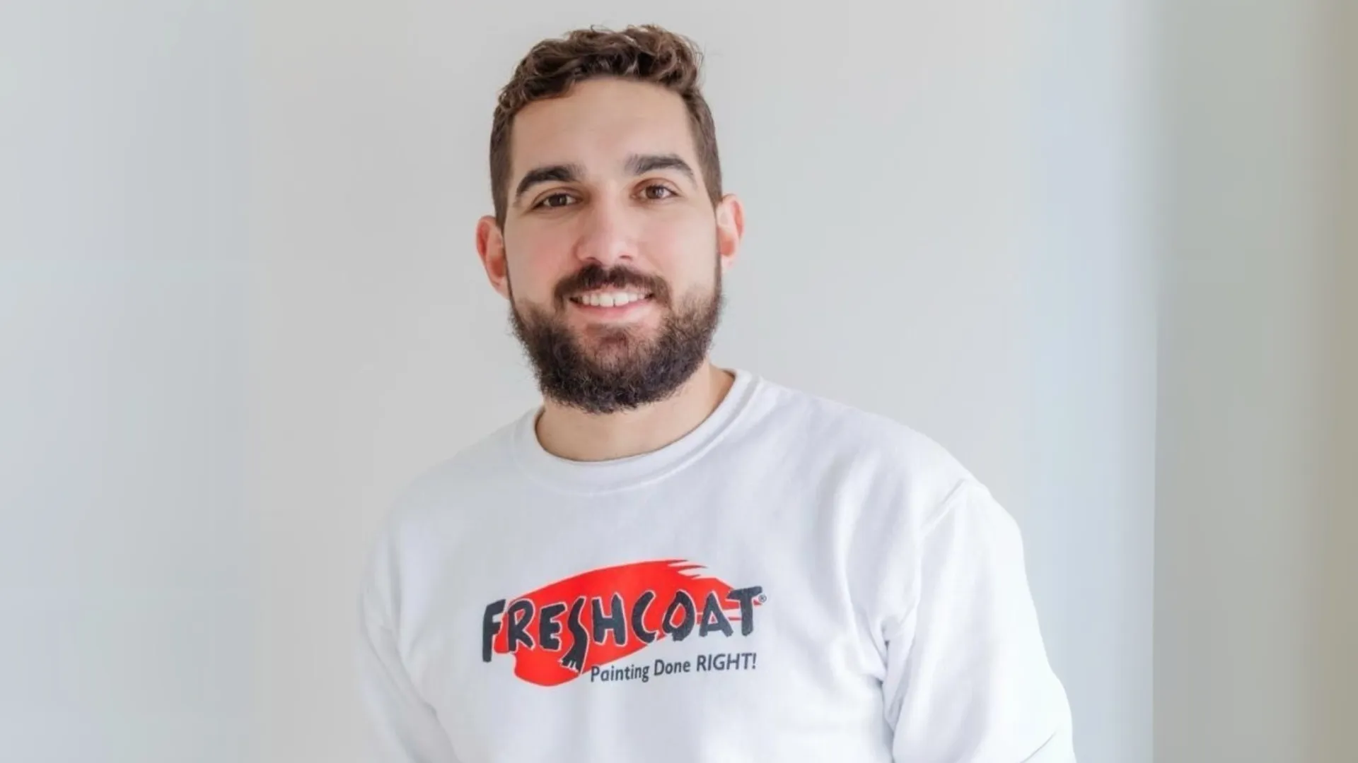 photo of Fresh Coat franchisee Alex Fonseca wearing branded crewneck against white background