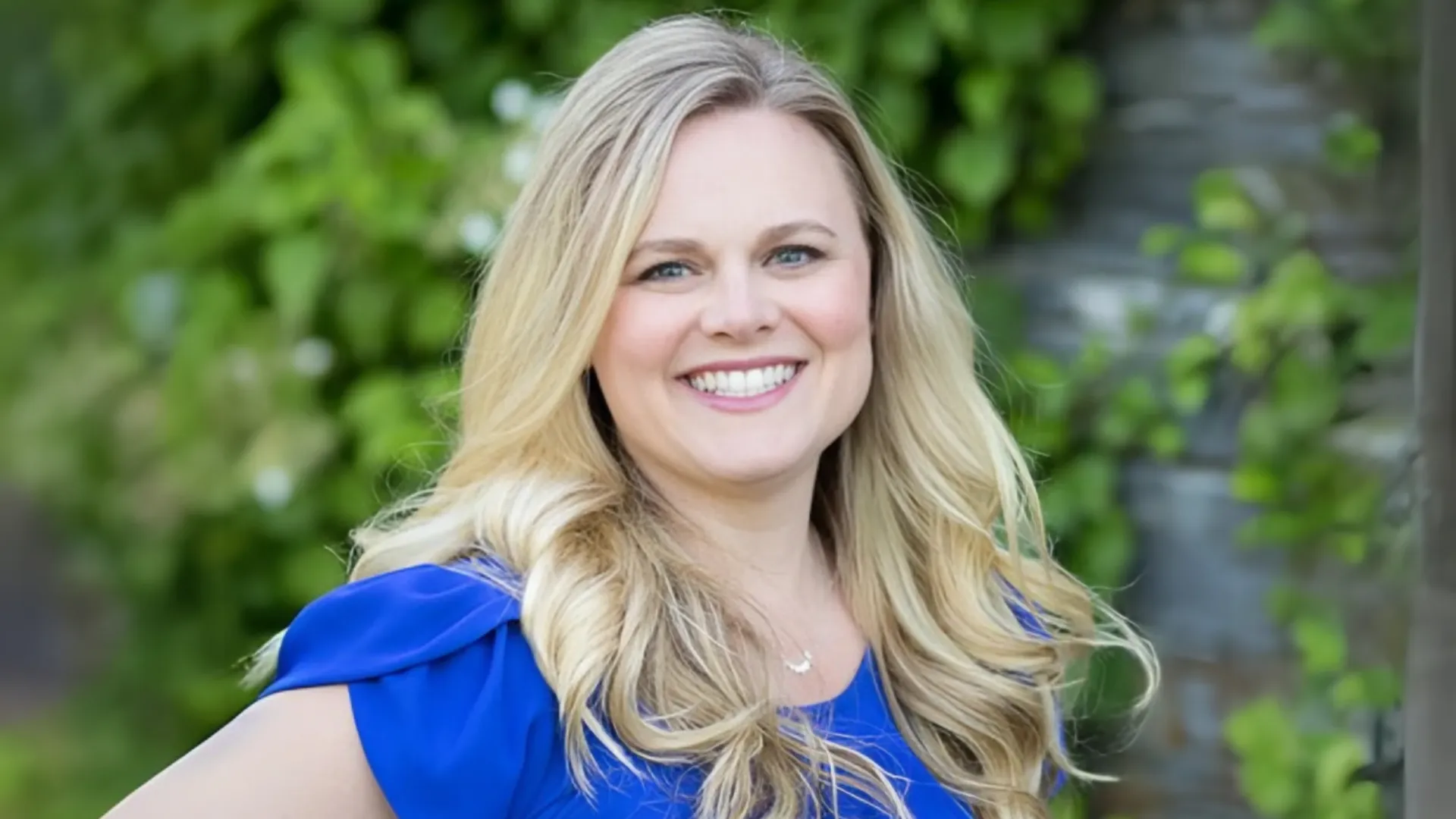 Headshot of Sharon Gates, who has long, blonde hair and is wearing a bright blue shirt