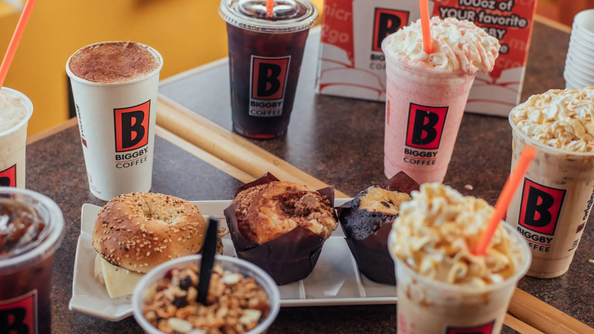 photo of BIGGBY COFFEE frozen, iced and hot beverages, and multiple bakery items, on a table