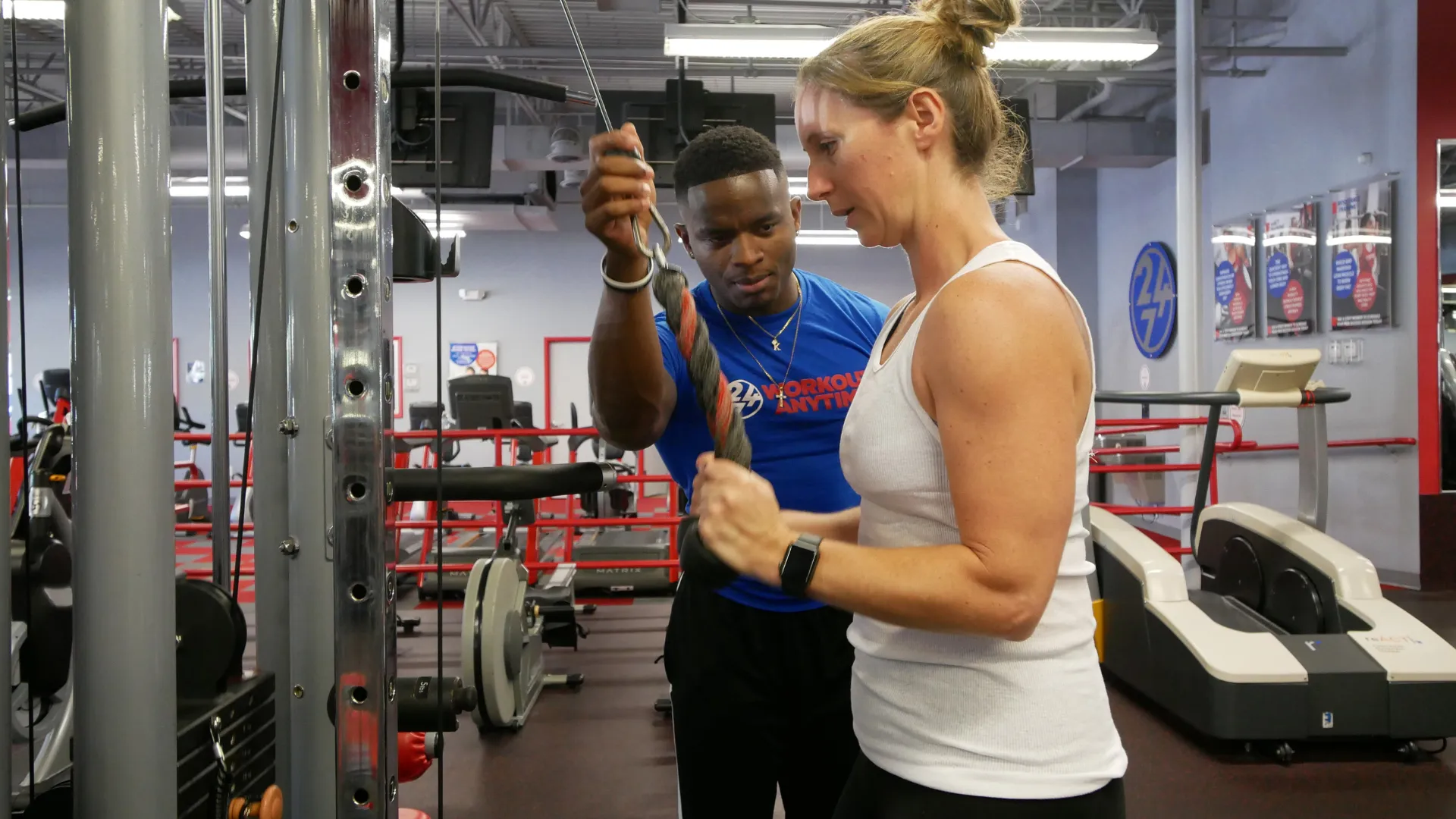 Photo of a trainer and client in Workout Anytime completing exercise at cable tower