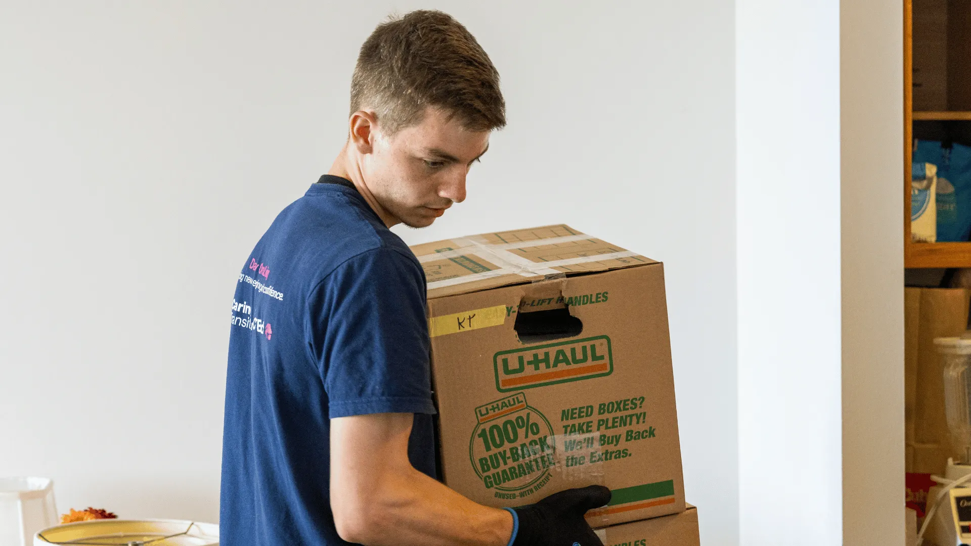 image of a man carrying boxes for a disabled person for caring transitions in a small town