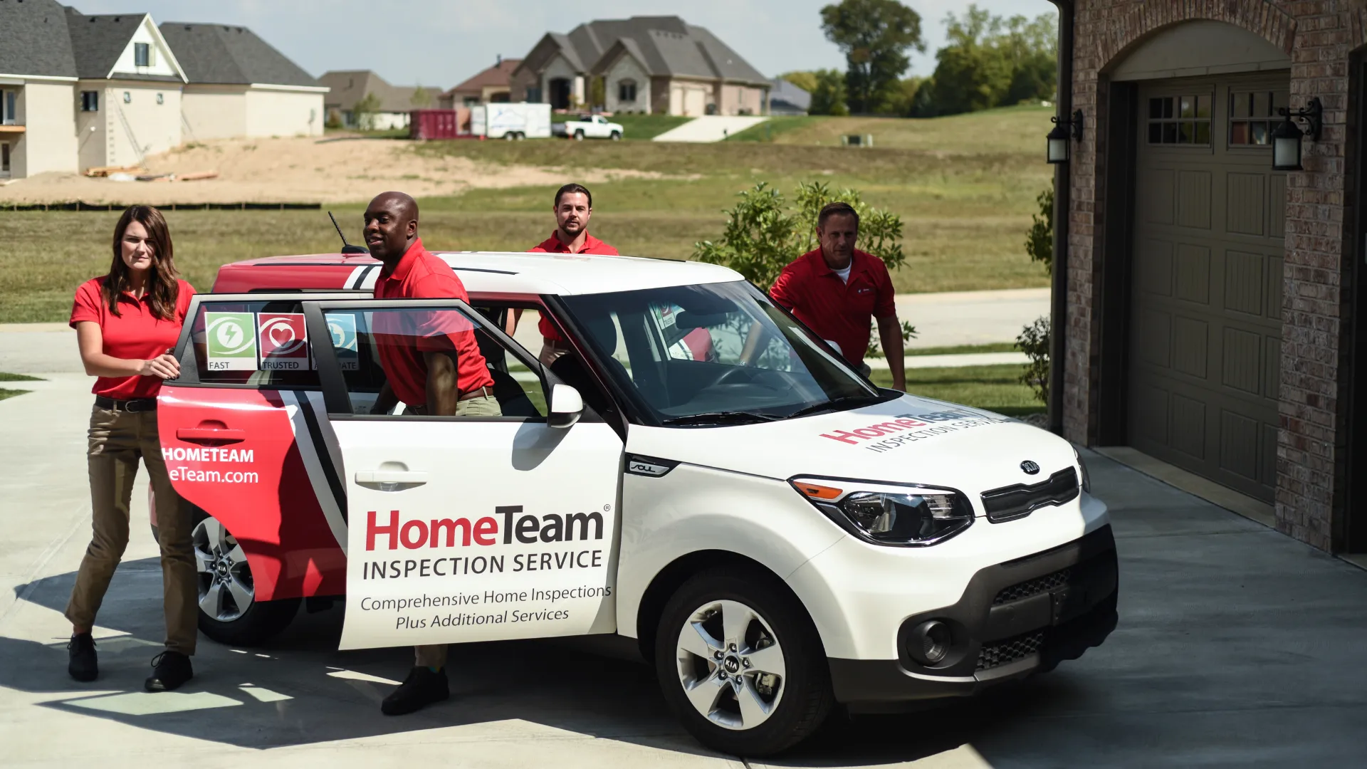 Team of home inspectors exiting branded HomeTeam Inspection Service vehicle