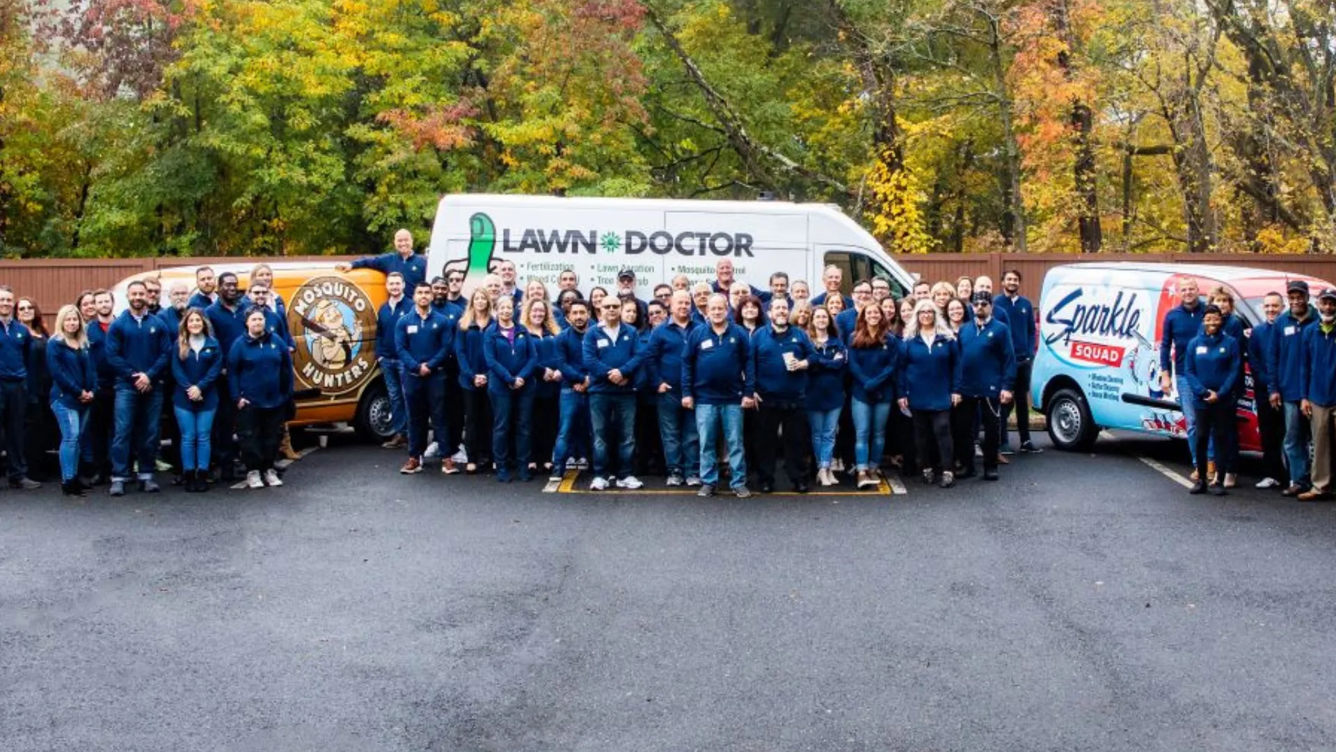 Photo of Happinest Brands teams standing together in front of branded vehicles