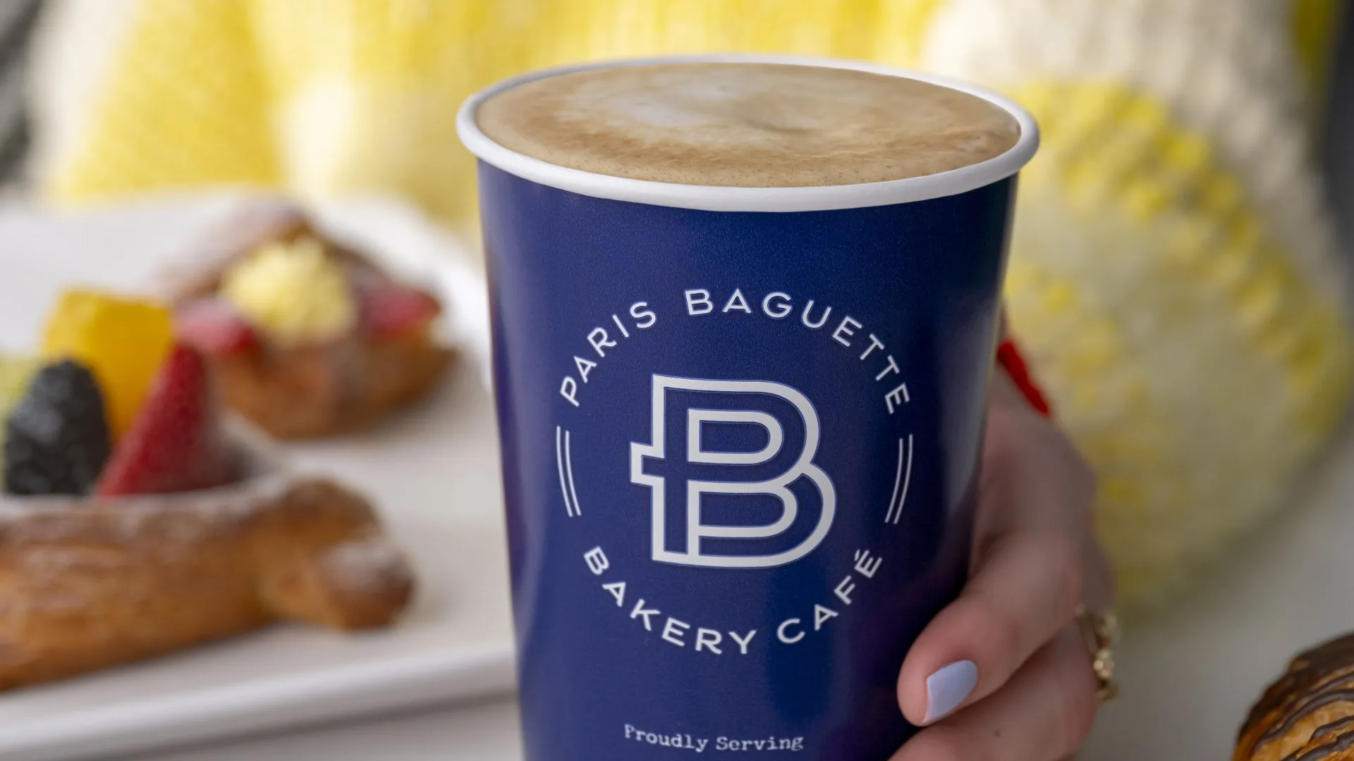 photo of Paris Baguette coffee cup with pastry plate in the background