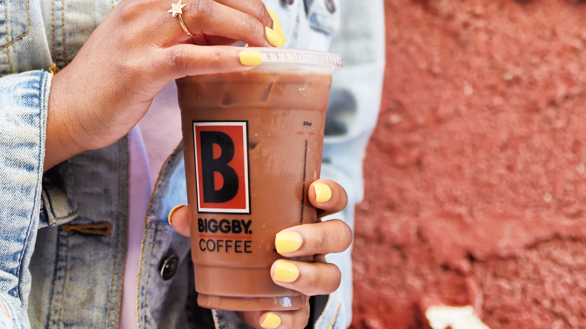 Photo of person holding iced BIGGBY COFFEE beverage