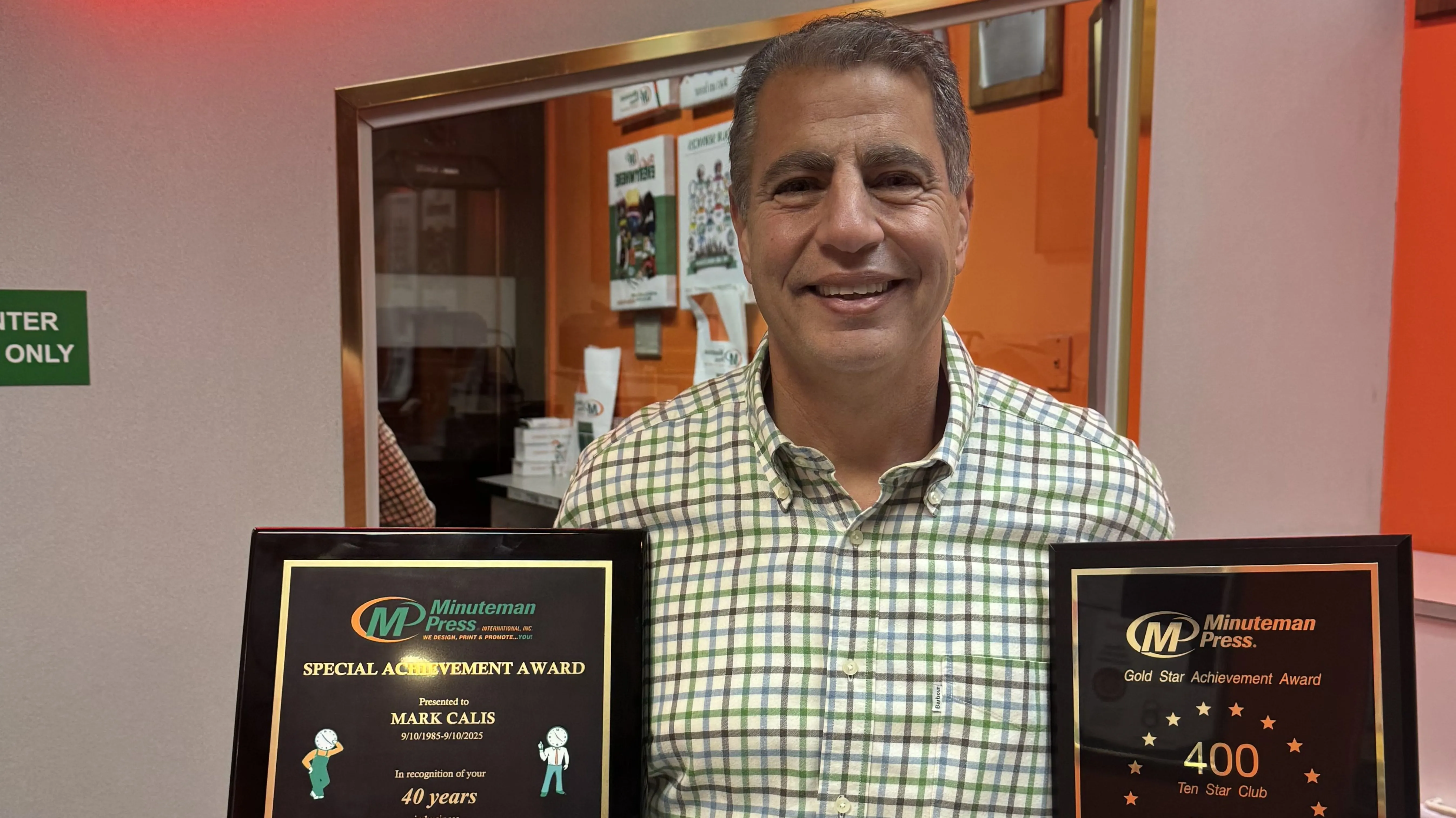 Minuteman Press Franchise Owner Mark Calis proudly displays his 40-Year Special Achievement Award.