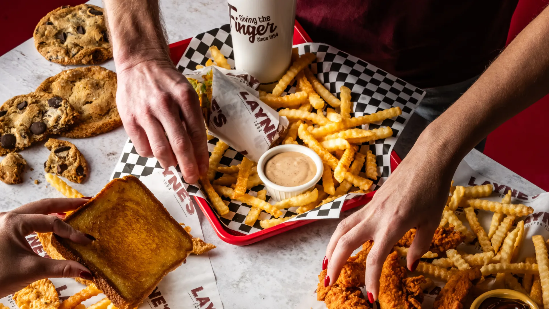 Photo of trays of Layne's fries, chicken fingers, wrap and toast on a table