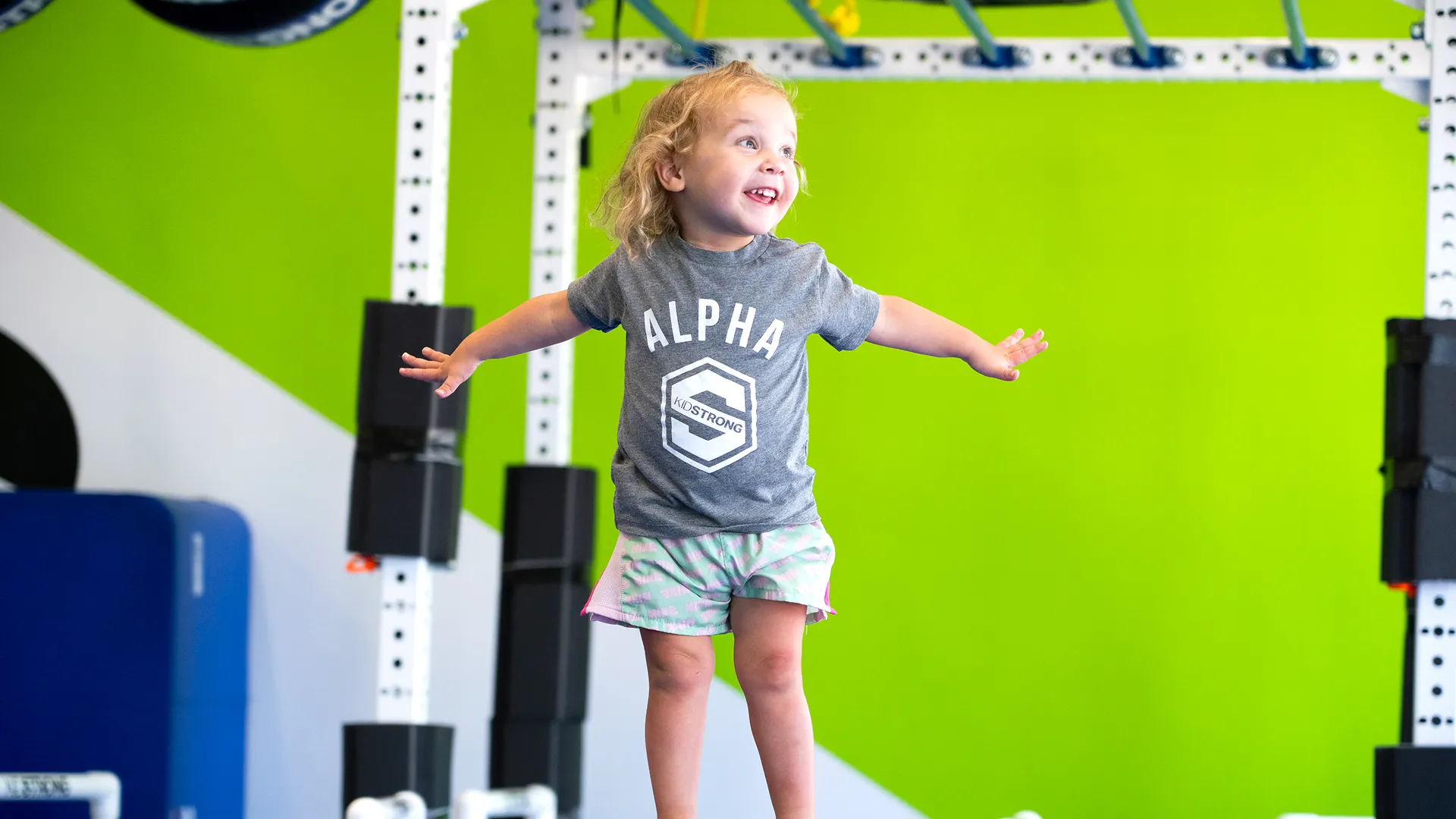 Photo of young child wearing KidStrong shirt, participating in KidStrong programming